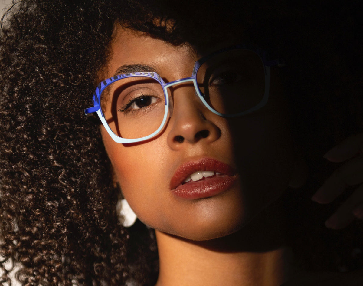 Close crop of a woman wearing blue and pale-blue angular Traction Productions frames